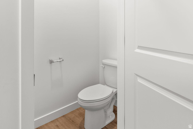 1417 West 2350th South, Unit 14 Perry, UT 84302 - Photo 15 of 19 Powder room featuring a white toilet, wood-finish flooring, white walls, and a white paneled door with brushed nickel hardware