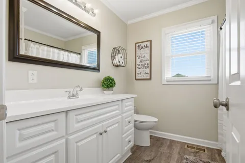 a bathroom with a granite countertop toilet sink and mirror