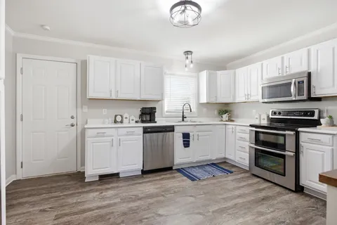a kitchen with stainless steel appliances granite countertop a stove a sink and a microwave