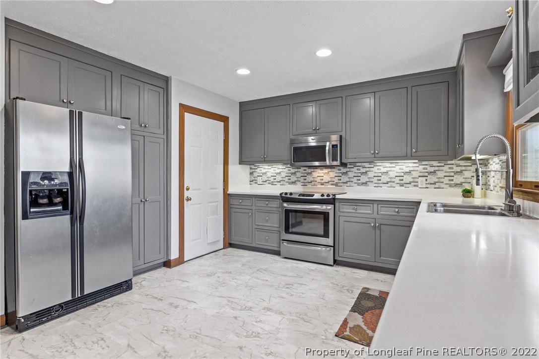 30480 East Lake Road Wagram, NC 28396 - Photo 18 of 49 a kitchen with stainless steel appliances granite countertop a refrigerator sink and stove