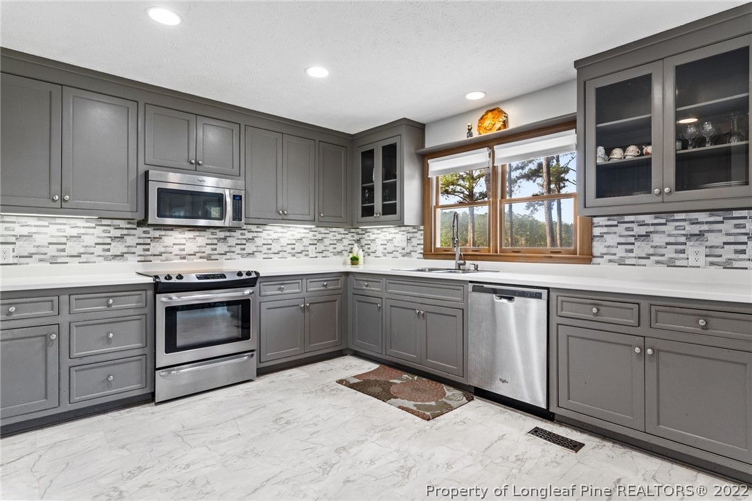 30480 East Lake Road Wagram, NC 28396 - Photo 19 of 49 a kitchen with stainless steel appliances granite countertop a sink and stove top oven