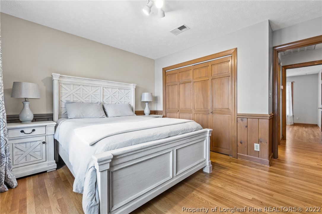 30480 East Lake Road Wagram, NC 28396 - Photo 28 of 49 a bedroom with a bed and wooden floor