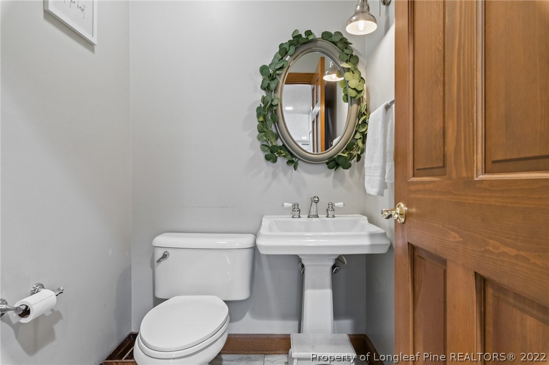 30480 East Lake Road Wagram, NC 28396 - Photo 34 of 49 a bathroom with a toilet a sink and a mirror