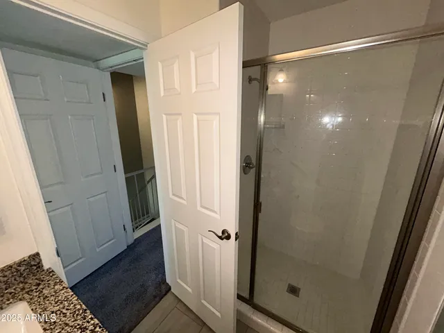 a bathroom with a glass door shower and a sink