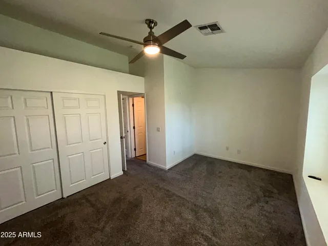 an empty room with a ceiling fan and a bathroom