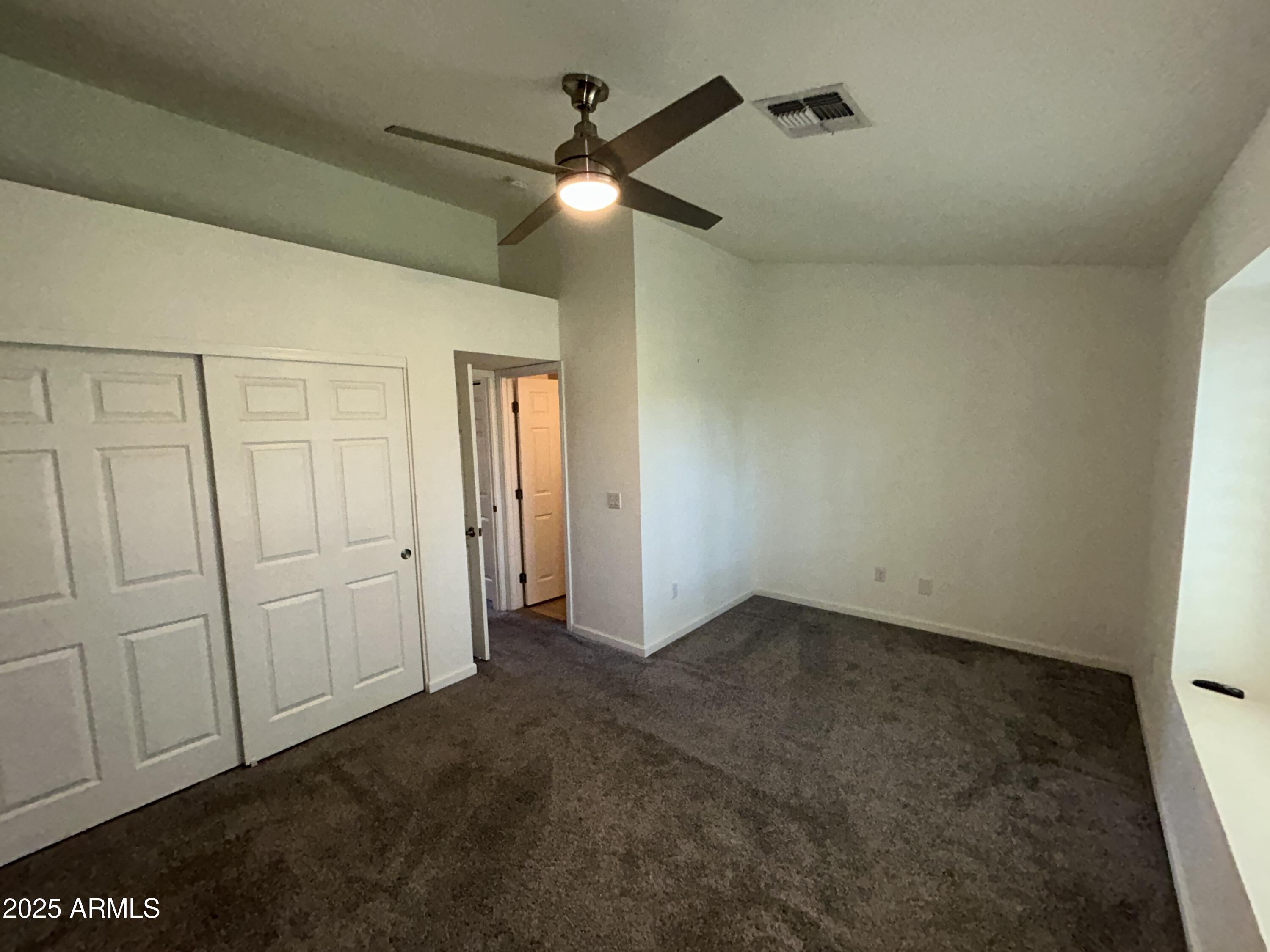9831 South 48th Way, Unit 4 Phoenix, AZ 85044 - Photo 16 of 21 an empty room with a ceiling fan and a bathroom