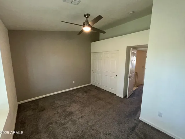 an empty room with a ceiling fan and a window