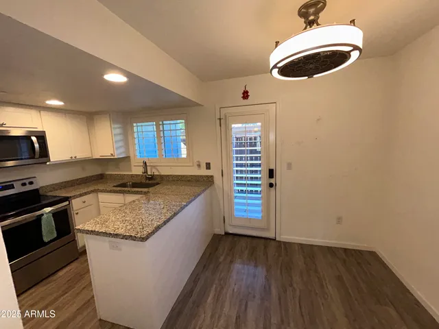 a kitchen with granite countertop a sink and a stove top oven