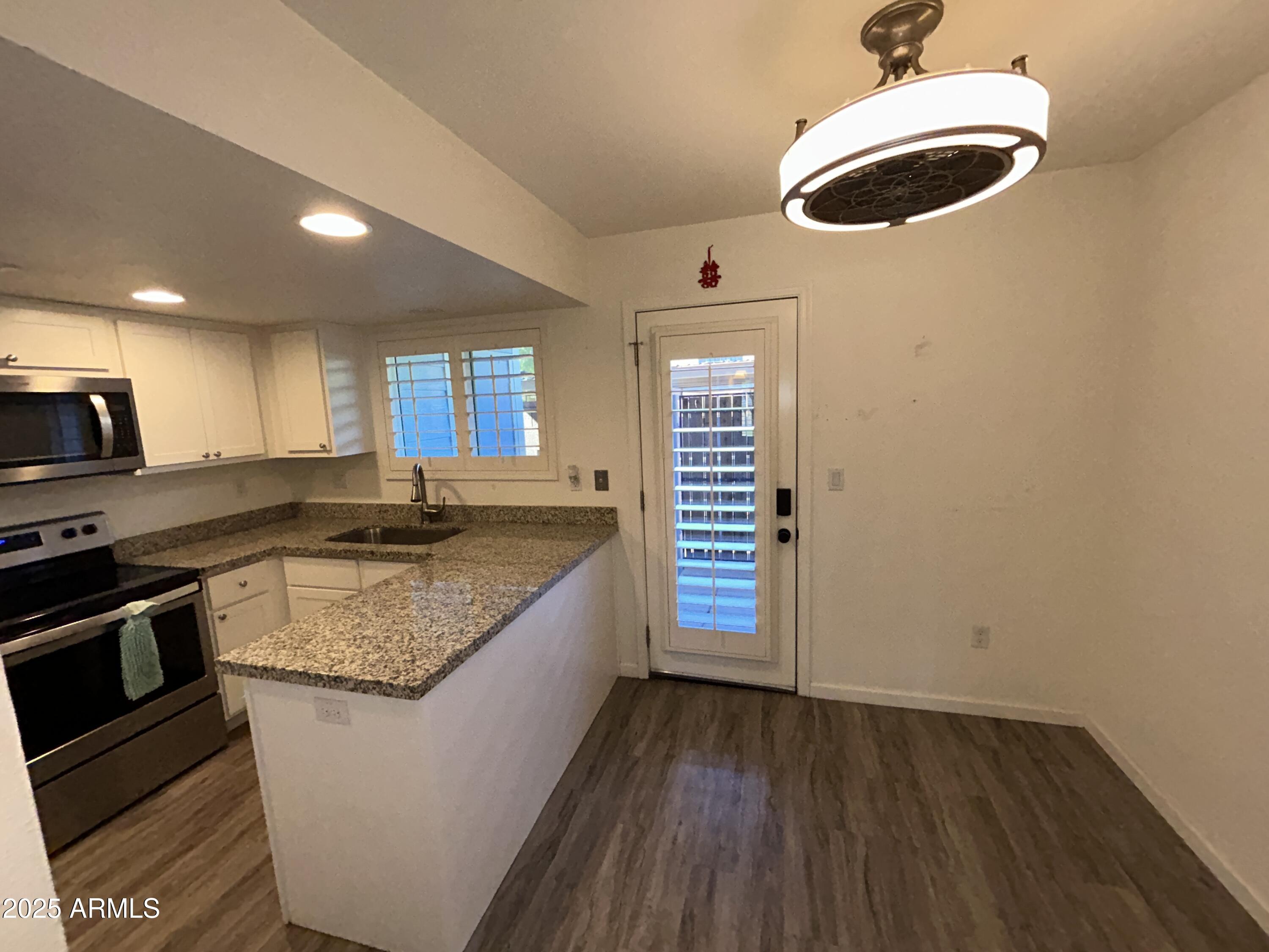 9831 South 48th Way, Unit 4 Phoenix, AZ 85044 - Photo 6 of 21 a kitchen with granite countertop a sink and a stove top oven