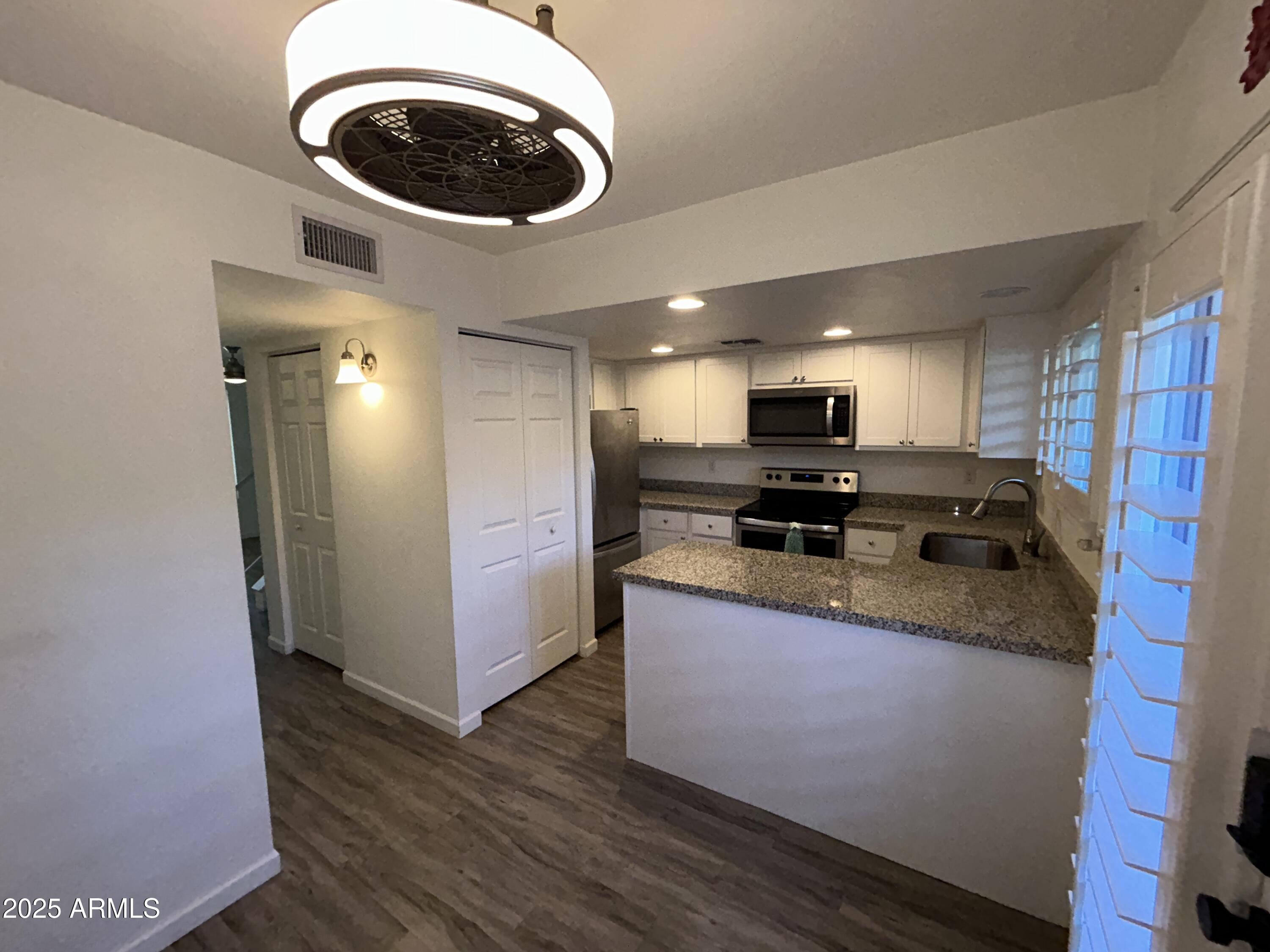 9831 South 48th Way, Unit 4 Phoenix, AZ 85044 - Photo 7 of 21 a kitchen with granite countertop a stove and a microwave