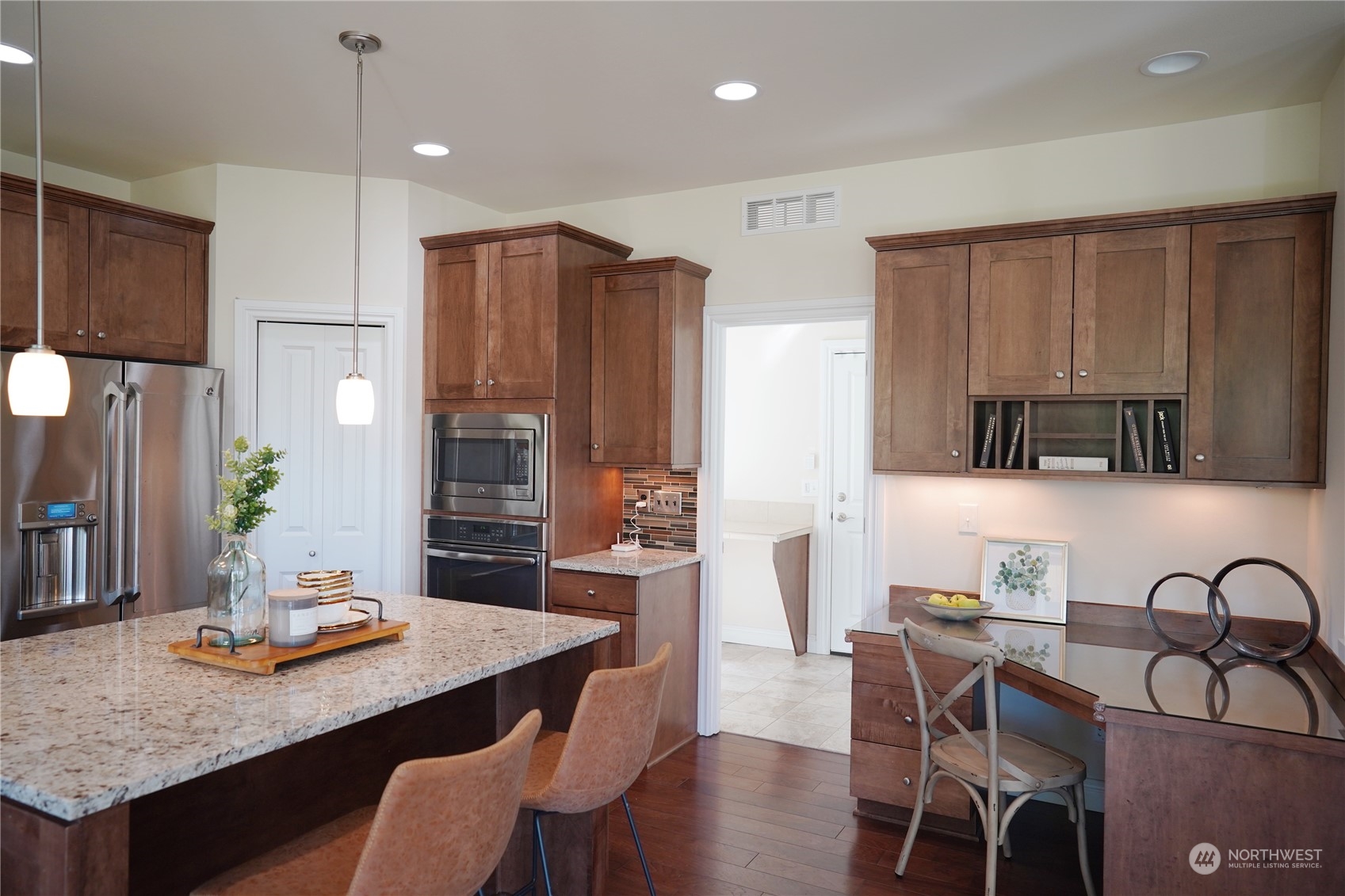 13763 173rd Place Southeast Renton, WA 98059 - Photo 10 of 40 a kitchen with granite countertop a table chairs stove and refrigerator
