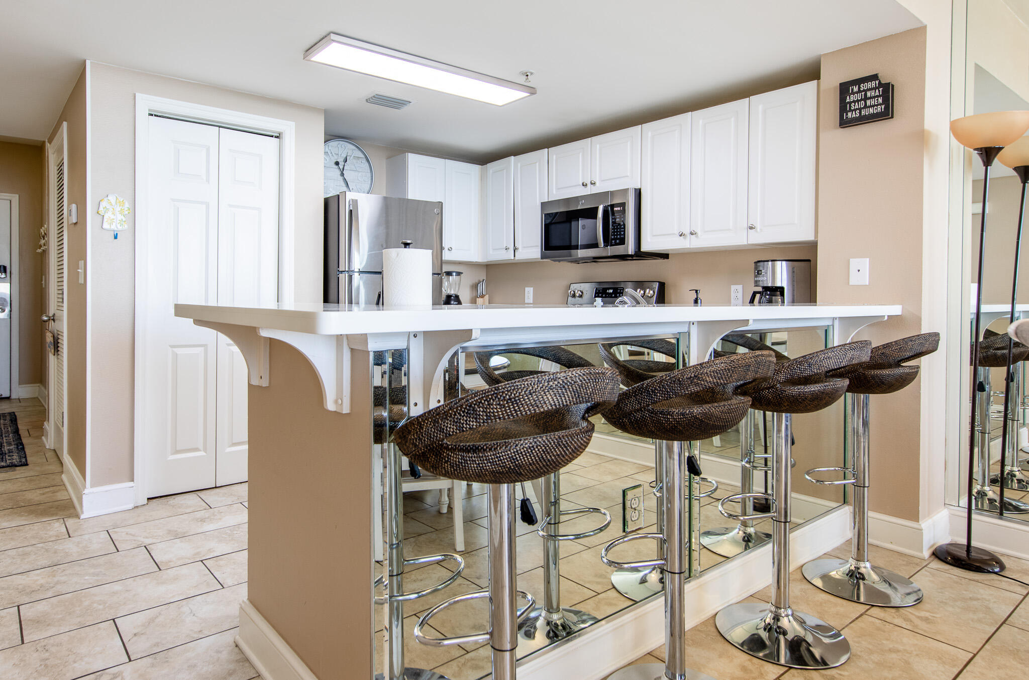 10901 Front Beach Road, Unit 2103 Panama City Beach, FL 32408 - Photo 18 of 54 a kitchen with stainless steel appliances kitchen island granite countertop a table and chairs in it