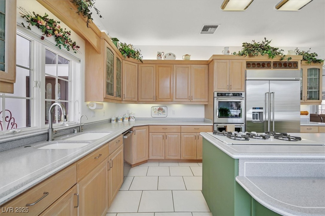 3938 East Russell Road Las Vegas, NV 89120 - Photo 23 of 57 Kitchen with light countertops, visible vents, appliances with stainless steel finishes, light brown cabinets, and a sink