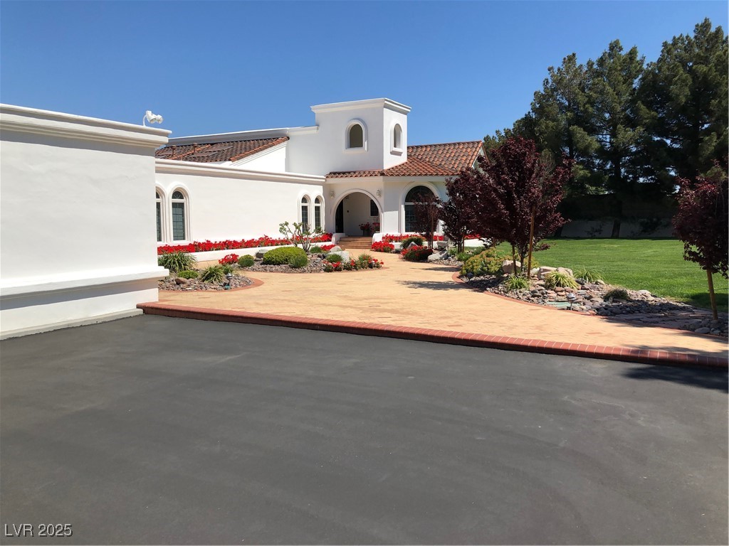 3938 East Russell Road Las Vegas, NV 89120 - Photo 55 of 57 Mediterranean / spanish-style home featuring a tile roof, a front yard, and stucco siding