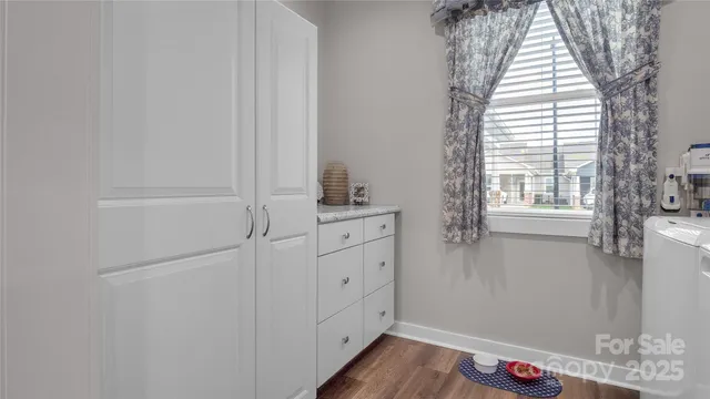 a kitchen with a sink a chandelier and living room view
