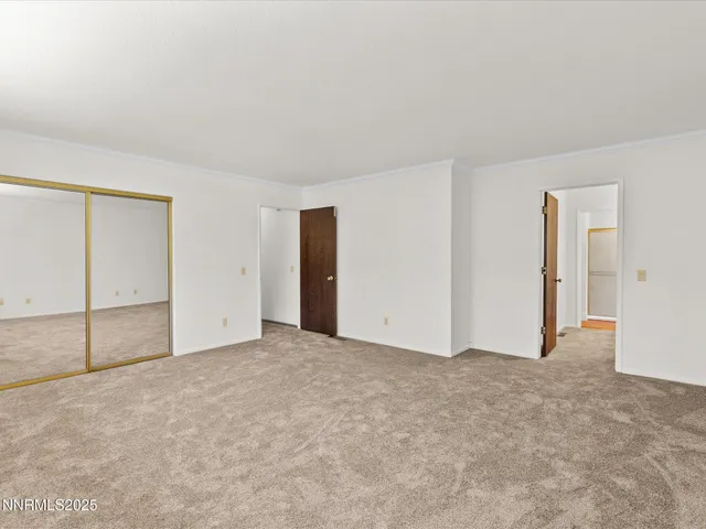 a front view of a building with a garden and trees