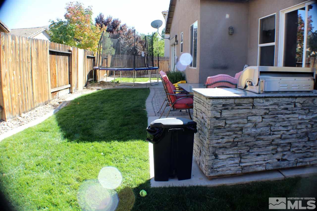 10558 Crystal Bay Drive Reno, NV 89521 - Photo 8 of 16 a backyard of a house with table and chairs plants and large trees