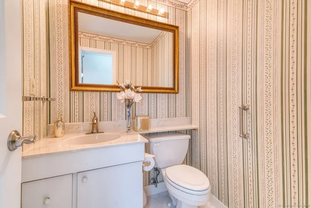 a bathroom with a sink a toilet and a mirror