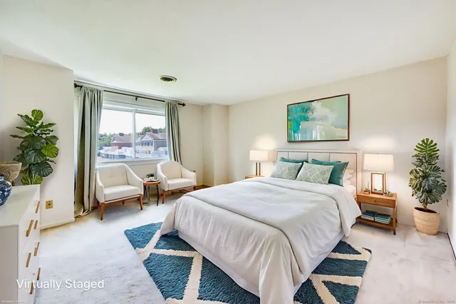 a bedroom with a bed and a large window