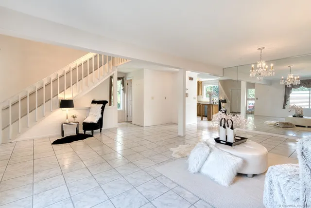 a room with lots of furniture and view of kitchen appliances