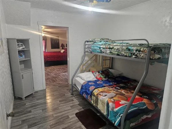 a bedroom with a bed and wooden floor