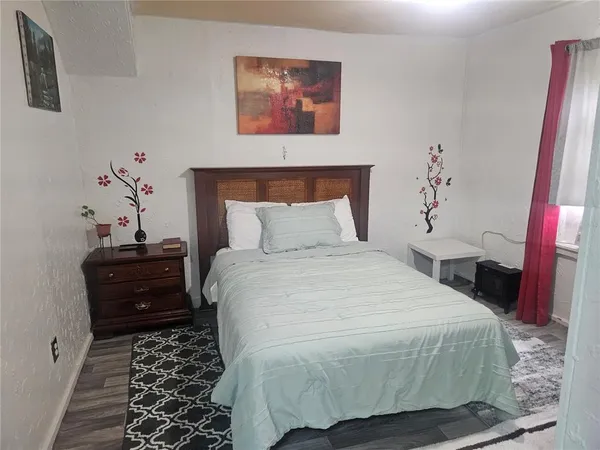 a bedroom with a bed and a mirror on the dresser