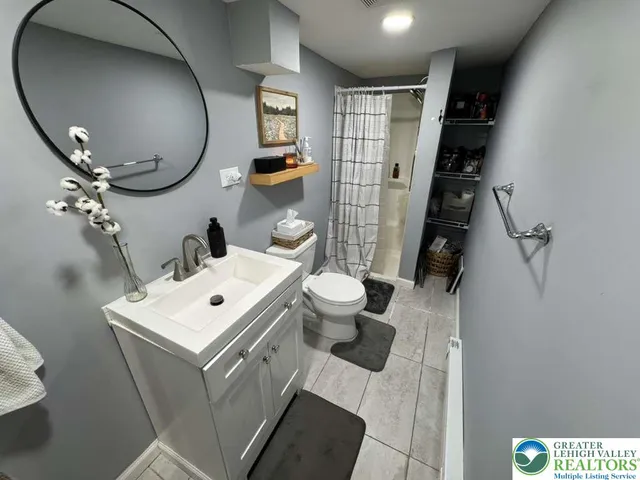 a bathroom with a sink mirror vanity and toilet