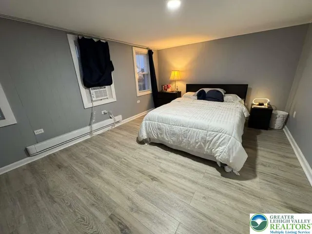 a bedroom with a bed and a flat tv screen on dresser