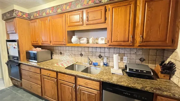 a kitchen with stainless steel appliances granite countertop a sink a stove and cabinets