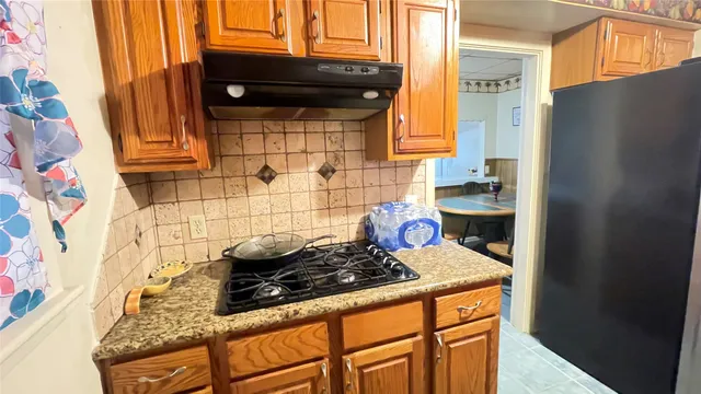 a kitchen with stainless steel appliances granite countertop a stove and a wooden cabinets