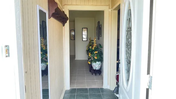 a view of a hallway with wooden floor and a dining room