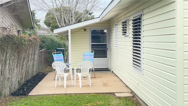 a view of a patio with table and chairs with wooden floor and fence