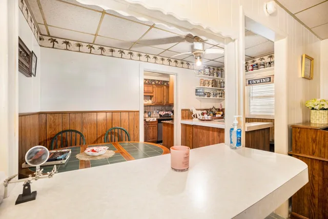 a bedroom with a bed and a table with the kitchen view