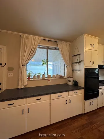 a kitchen with granite countertop white cabinets and white appliances