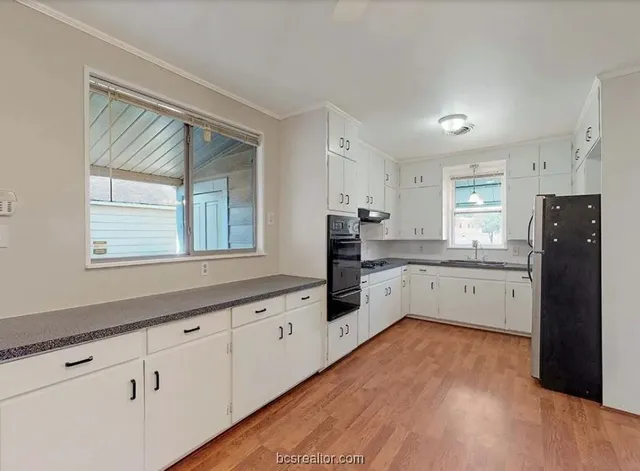 a kitchen with granite countertop white cabinets and white appliances