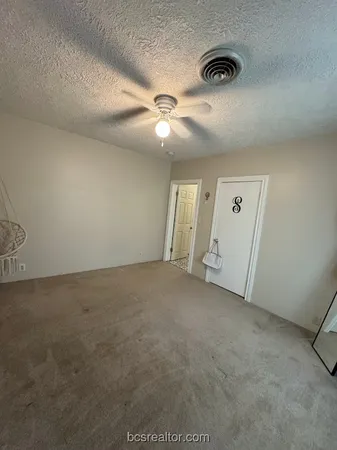 an empty room with windows and fan