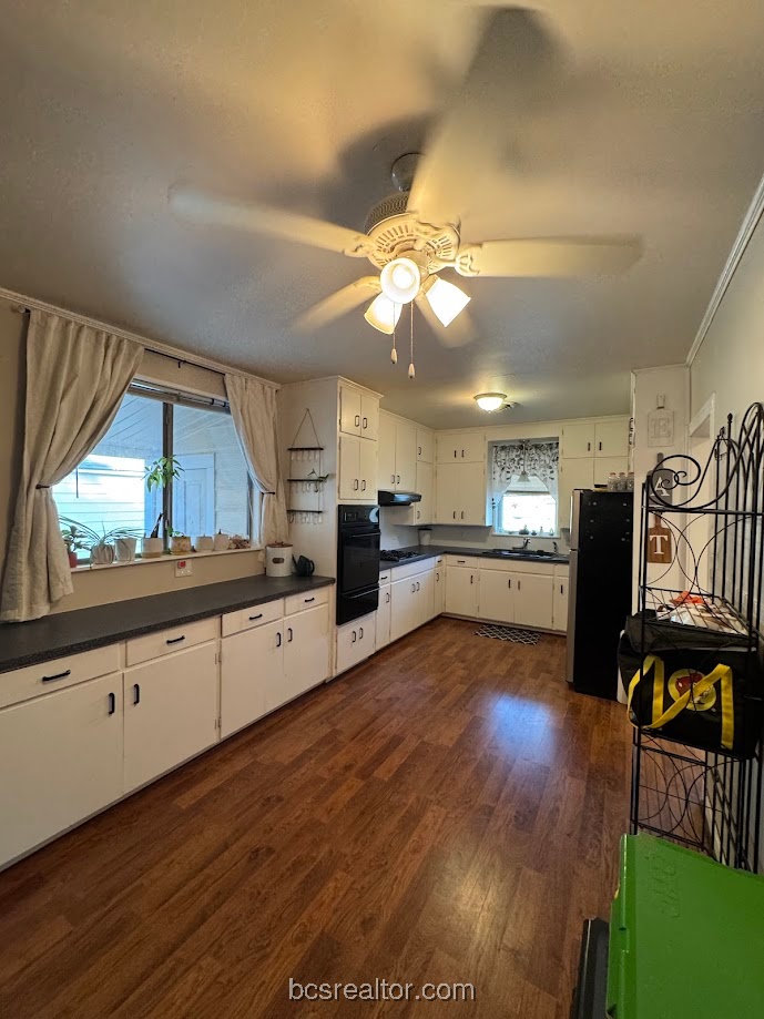 1101 East 30th Street Bryan, TX 77802 - Photo 9 of 42 a large kitchen with cabinets wooden floor and stainless steel appliances