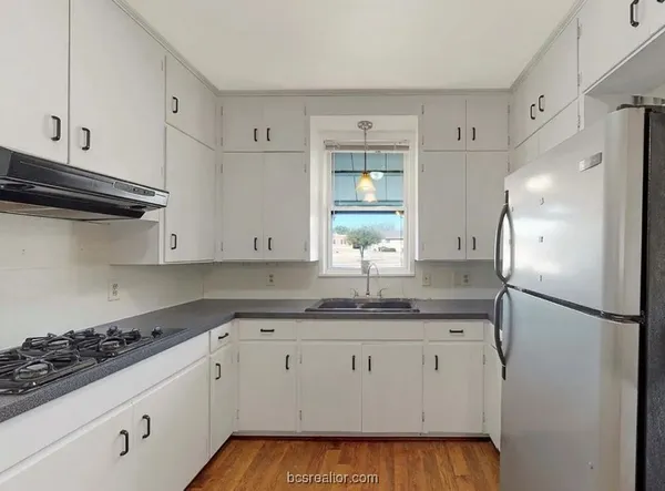 a kitchen with a sink stove and refrigerator