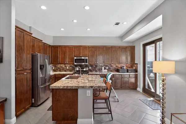 a kitchen with refrigerator and chairs