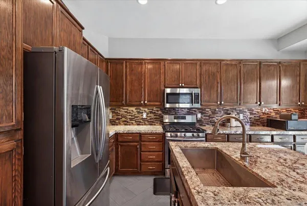 a kitchen with granite countertop a sink stove and refrigerator