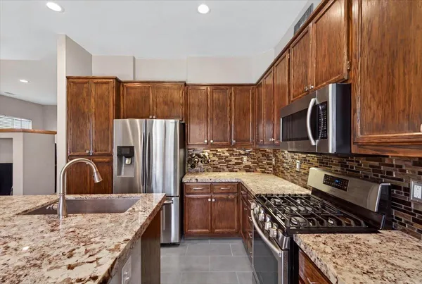 a kitchen with stainless steel appliances granite countertop a sink and a stove