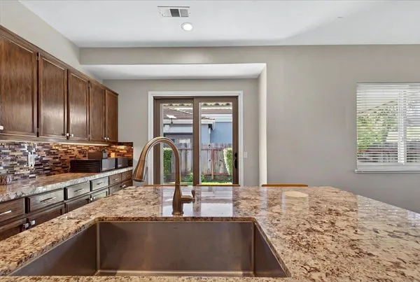 a kitchen with stainless steel appliances granite countertop a stove top oven a refrigerator a sink and dishwasher