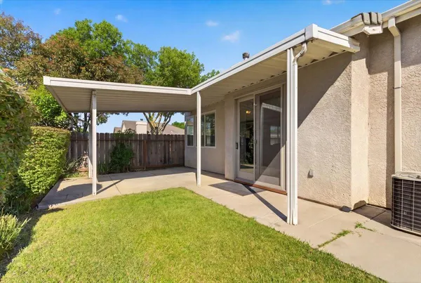 a view of a house with backyard and sitting area
