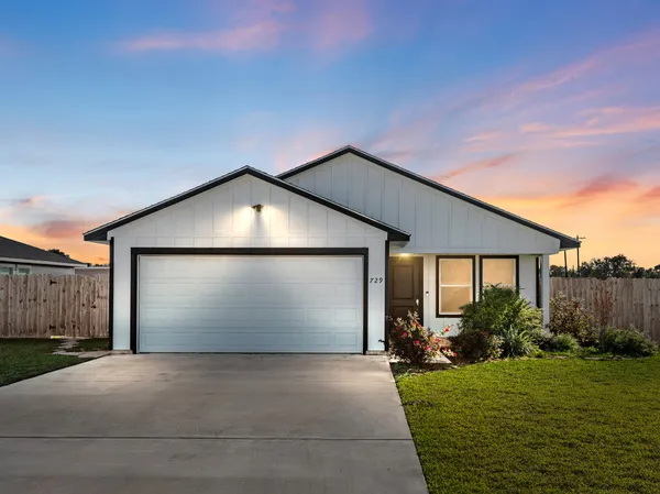 a front view of house with yard and garage