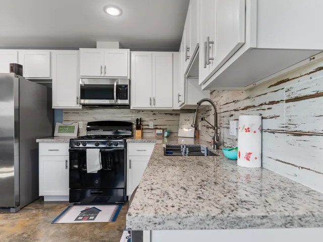 a kitchen with stainless steel appliances granite countertop a stove and a microwave