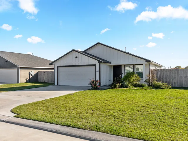 a front view of house with yard and garage