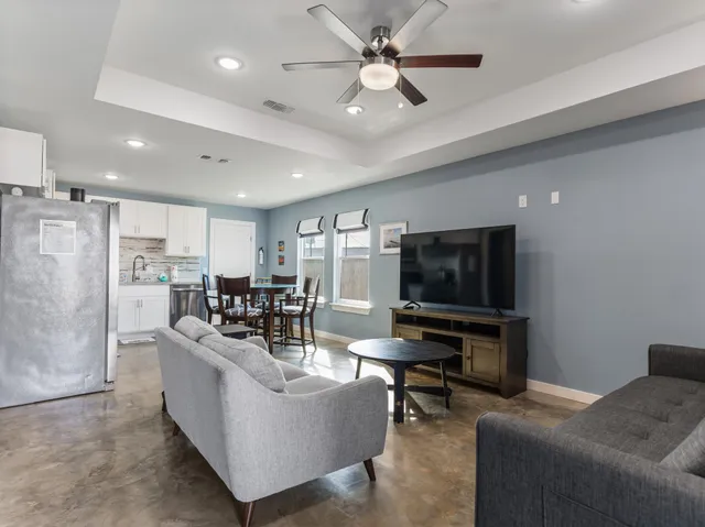 a living room kitchen with furniture and a dining table with kitchen view