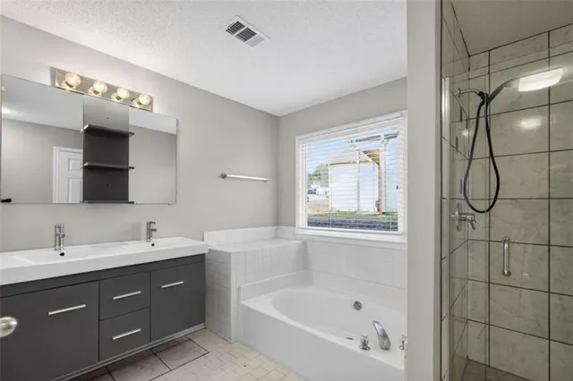 a bathroom with a tub a sink and mirror