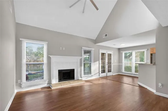 an empty room with wooden floor and fireplace