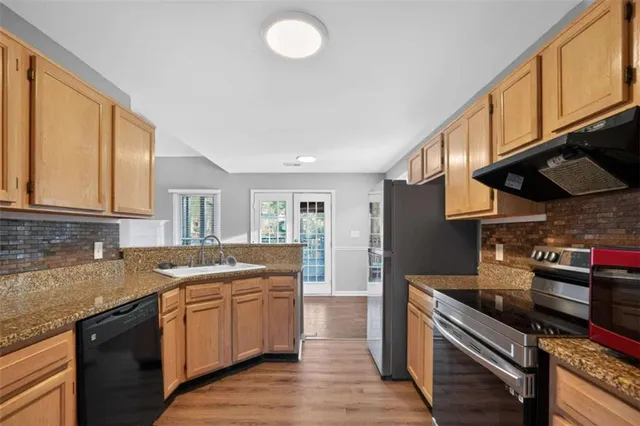 a kitchen with stainless steel appliances granite countertop a sink stove and cabinets